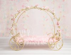 a gold carriage with pink flowers and a monogrammed name