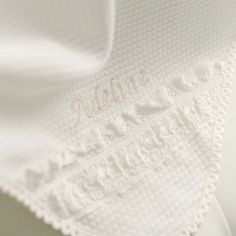 an embroidered white blanket with the word addams on it's side and gold lettering