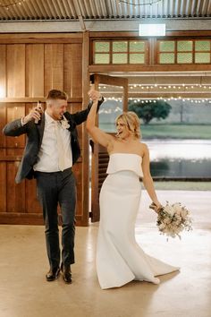 a bride and groom holding champagne flutes in the air