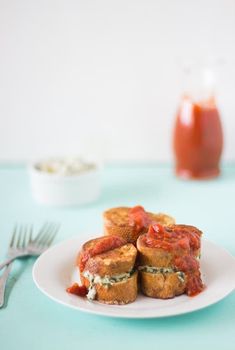 some food is on a white plate with silverware and a bottle of ketchup in the background