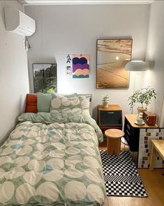 a bed sitting in a bedroom next to a wooden table and two pictures on the wall