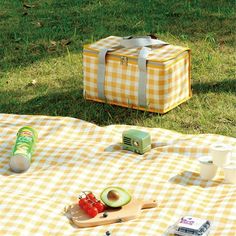 an open picnic bag sitting on top of a yellow and white checkered table cloth