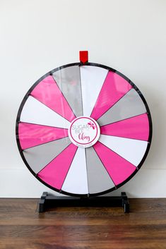 a pink and white spinning wheel on top of a wooden floor