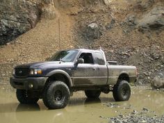 the truck is driving through some muddy water