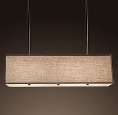 a rectangular light fixture hanging from a ceiling in a room with dark walls and flooring