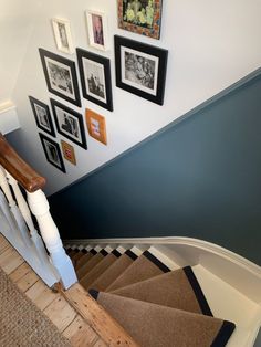 a staircase with pictures on the wall and carpeted steps leading up to the second floor