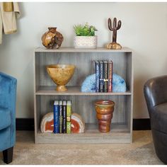 a book shelf with books, vases and other items on it in a living room