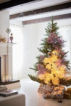 a decorated christmas tree in the middle of a living room next to a fire place