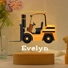 a wooden block with a yellow forklift on it and the word evelyn written in white