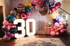 the number 30 is surrounded by balloons and disco balls