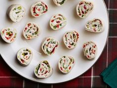 small appetizers are arranged on a white plate with red and green napkins