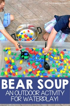 two children playing with bear soup in an outdoor activity tray