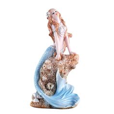 a figurine of a mermaid sitting on top of a fish with her hair blowing in the wind