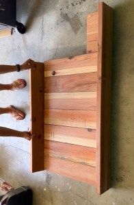 two people standing next to each other in front of a wooden table with legs on it