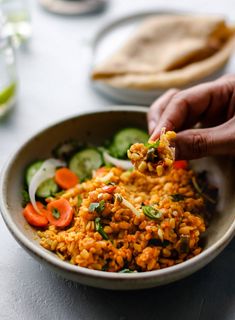 a bowl filled with rice and vegetables on top of a table