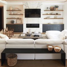 a living room filled with furniture and a flat screen tv mounted on the wall above a fireplace