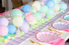 a table topped with lots of balloons and paper plates