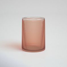 a pink glass sitting on top of a white table