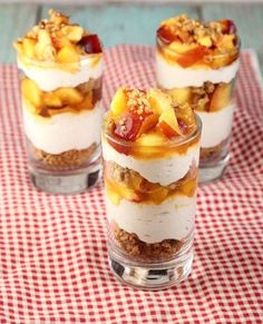 three small desserts are sitting on a red and white checkered tablecloth,