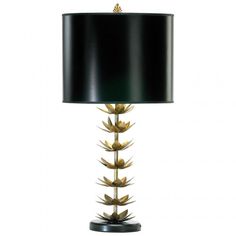 a table lamp with a black shade on it and gold leaves in the bottom corner