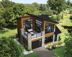 an aerial view of a modern home in the woods