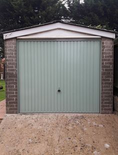 a garage with a brick wall and green door