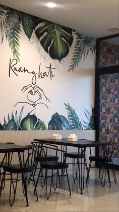 the interior of a restaurant with tables and chairs in front of a wall mural that reads kann glat