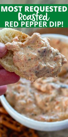 a hand holding a cracker with dip in it and the words most popular roasted red pepper dip