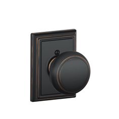 an image of a black knob on a white wall with the door handle in bronze