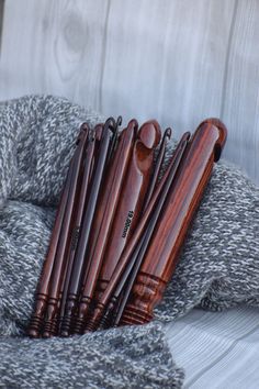 a pile of wooden utensils sitting on top of a gray and white blanket