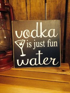 a wooden sign that says vodka is just fun water on top of a wood shelf