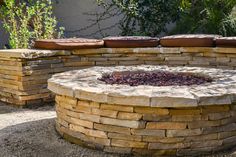 an outdoor fire pit surrounded by stone walls