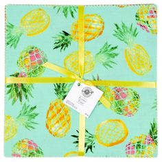 a blue wrapping paper with pineapples on it and a yellow ribbon around the edge