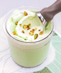 a cup filled with whipped cream and pistachio