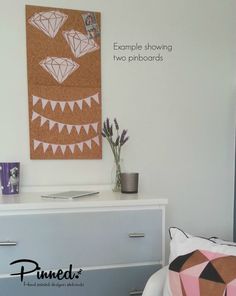 a white dresser topped with drawers next to a wall mounted art piece on the wall