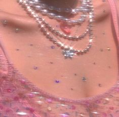 a close up of a woman's breast with beads and necklaces on it