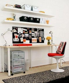 a white desk topped with a red chair next to a black and white area rug