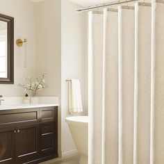 a bathroom with a sink, mirror and bathtub next to a shower curtain in it