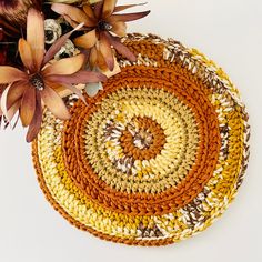 two crocheted placemats with flowers in the middle on a white surface