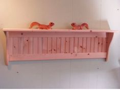 two pink wooden shelfs with squirrel figurines on top