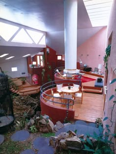 a living room filled with furniture next to a tall white pillar in the middle of a room