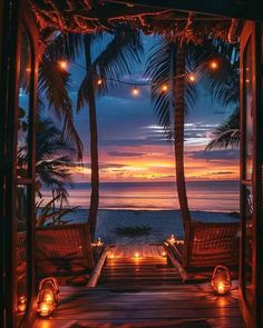 an open door leading to the beach at night with candles lit up in front of it