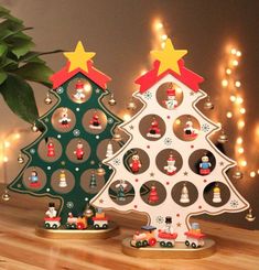 two wooden christmas trees sitting on top of a table