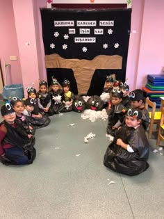 a group of children in costumes sitting on the floor