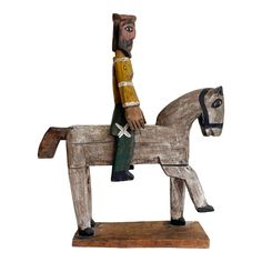 a wooden toy horse with a man on it's back sitting in front of a white background