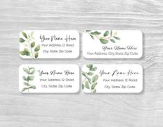 four business cards with watercolor eucalyptus leaves on them, sitting on a wooden surface