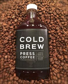 a bottle of cold brew sits on top of coffee beans