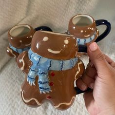 someone is holding two coffee mugs in the shape of an elephant and snowman