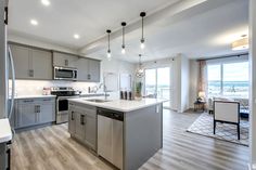 a large kitchen with stainless steel appliances and wood flooring is pictured in this image