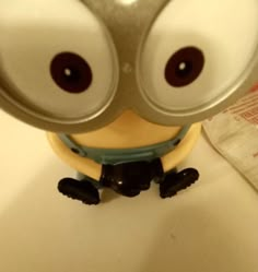 a minion with big eyes sitting on top of a counter